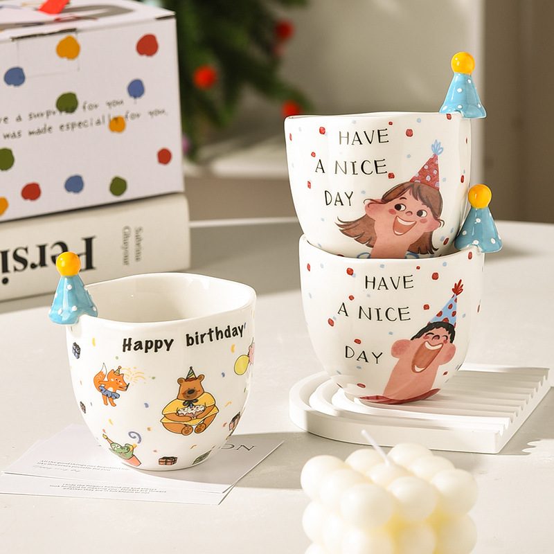 Character mugs with hand-painted faces and party-hat toppers